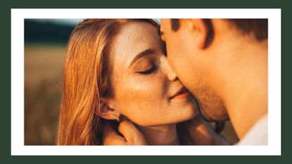 Couple kissing in a field outdoors