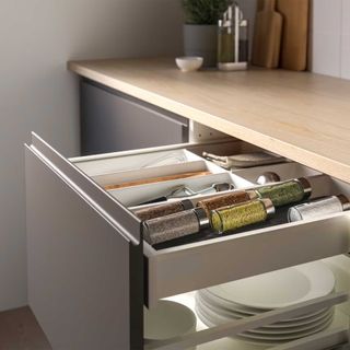 grey kitchen drawer open showing a storage tray to demonstarte how to organise kitchen drawers with spices