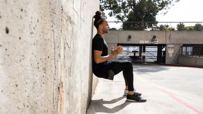Man doing wall sits squats outdoors