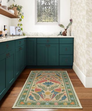 Kitchen with green cabinets and rug