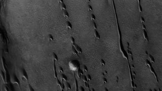 An aerial black and white photo showing strange shapes in the sand