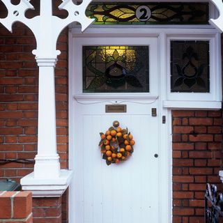 brick walls with white door and wreath