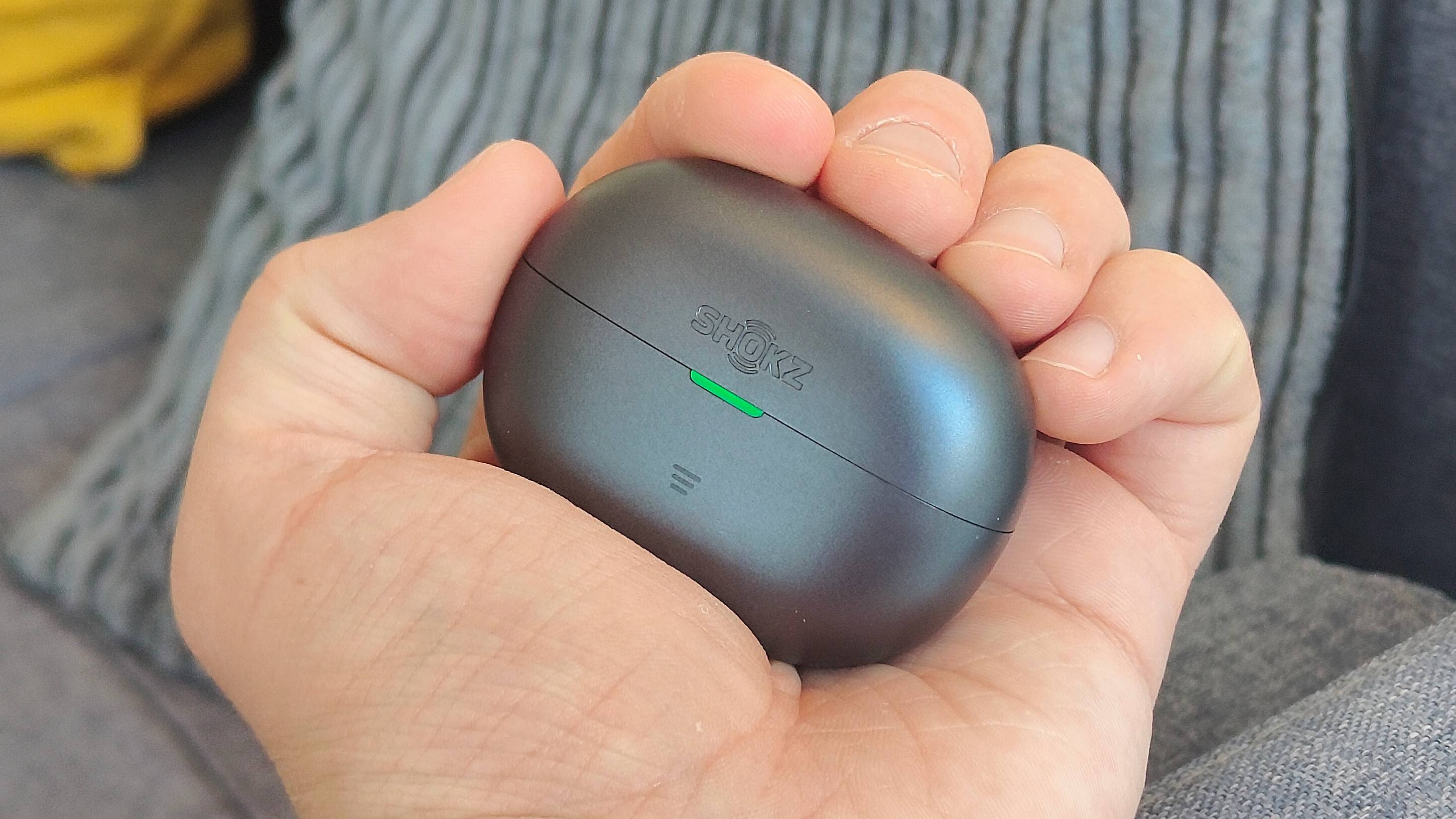 The Shokz OpenDots Air case in a man's hand.