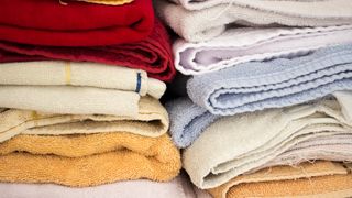 Old mixed assortment of towels stacked in closet