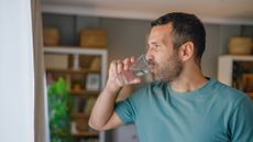 Man drinking water in domestic setting