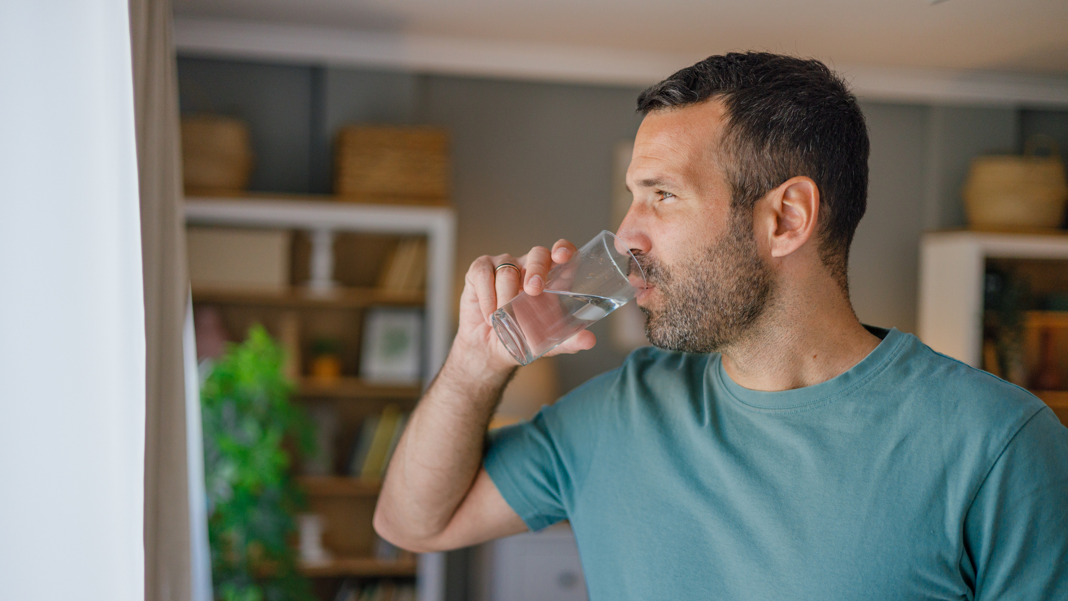 Man drinking water in domestic setting