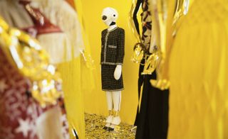 Amid silver streamers and acid yellow walls, Chanel presents a vision of the future, topping off a metallic tweed skirt-suit with a space-age helmet and avant-garde boots