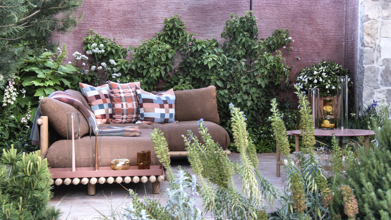 Plants in borders and vertically trained shrubs around a deck seating area