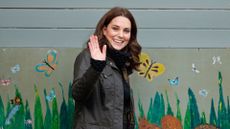 Kate Middleton waving, wearing green Barbour jacket