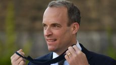 Dominic Raab removes his protective face mask.