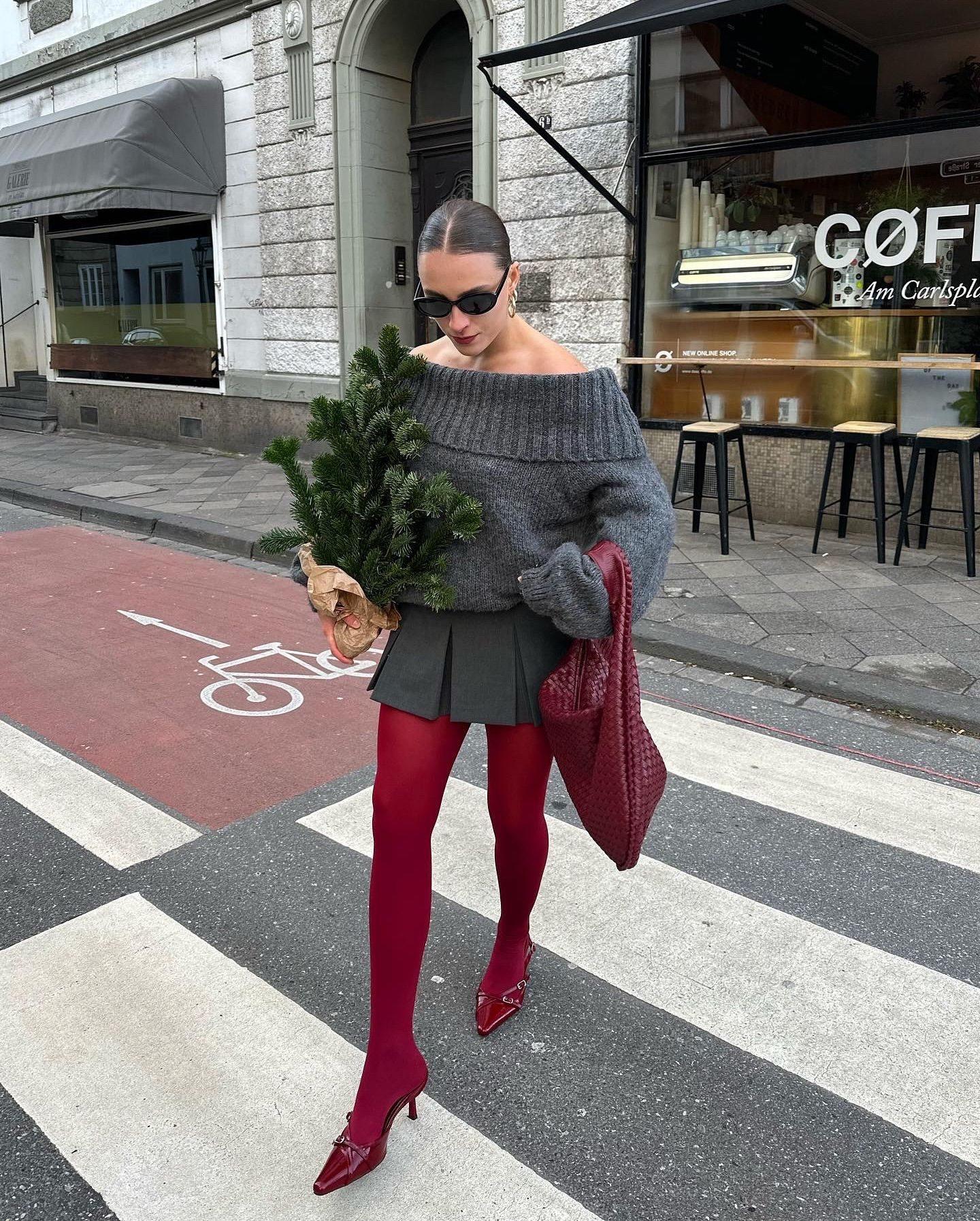 Fashion influencer @lara_bsmnn wearing a chic winter outfit styled with 2024/2025's burgundy tights trend.