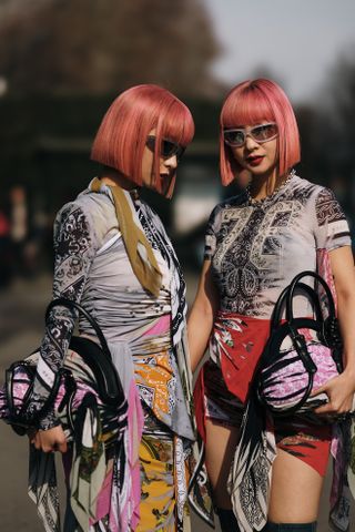 two women with pink bobs and colorful dresses