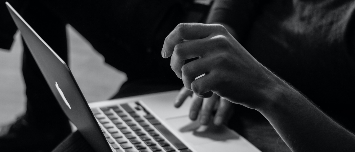 Woman&#039;s hand hovering over a laptop in black and white