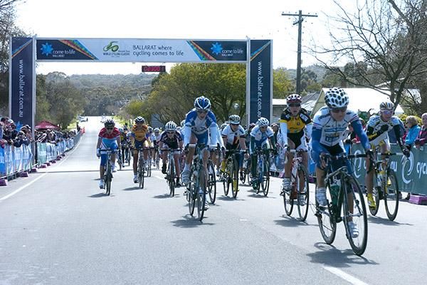 The peloton roll in beneath the banner in Buninyong, around three minutes behind race winner Trixi Worrack from Germany.