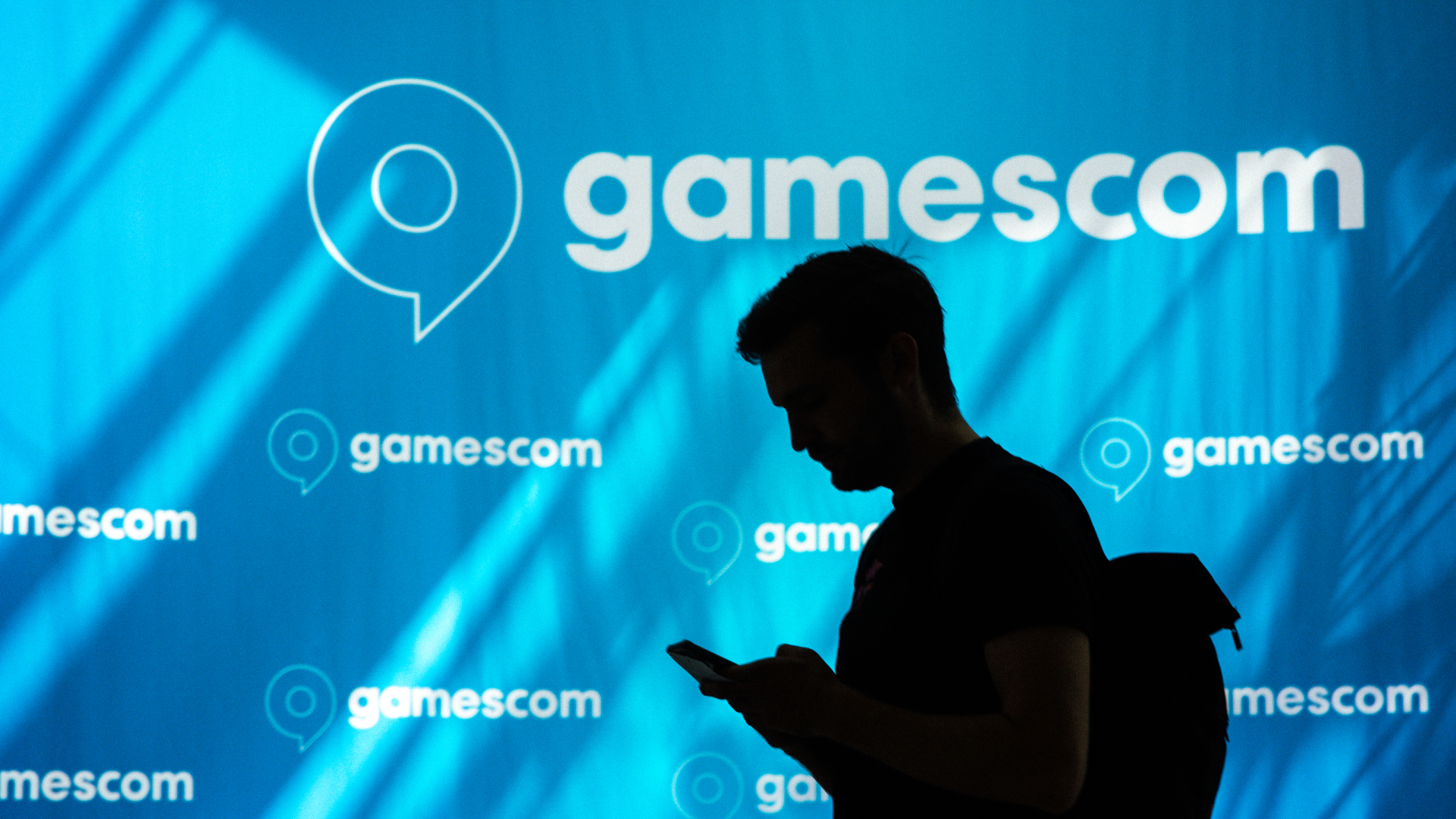A general view of a tradefairgoer is seen walking past the Gamescom logo during the opening day of Gamescom at the Cologne Trade Fair Center in Cologne, Germany on August 23, 2023.