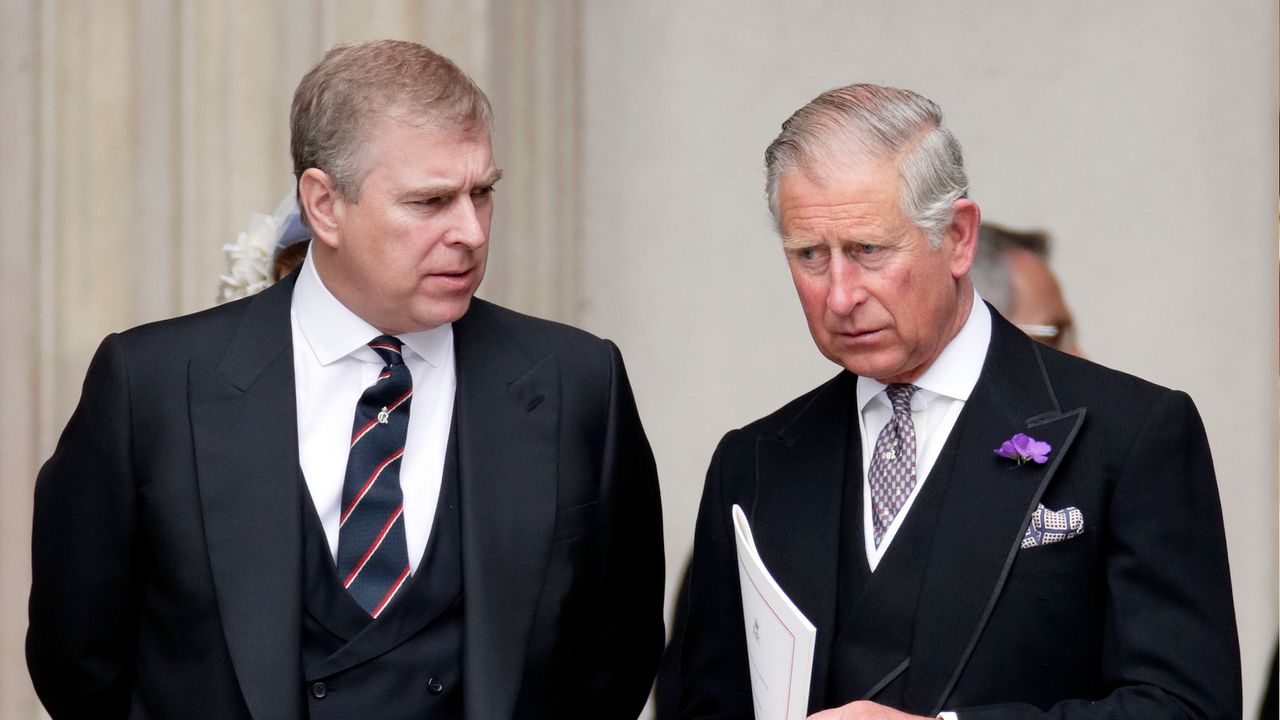 King Charles and Prince Andrew wearing dark suits, ties and serious expressions 