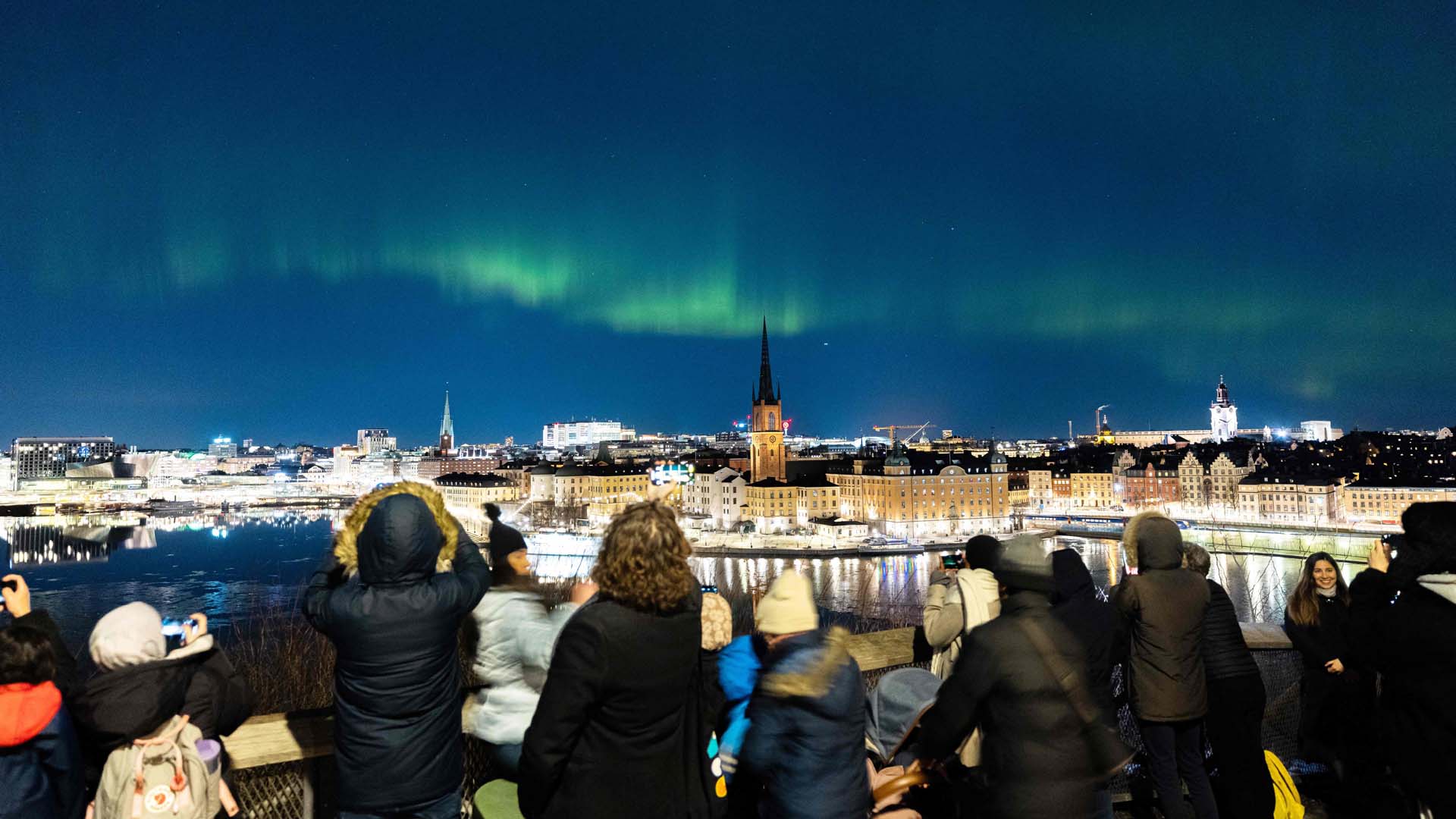 People watch aurora borealis, in central Stockholm, on Feb. 27, 2023.