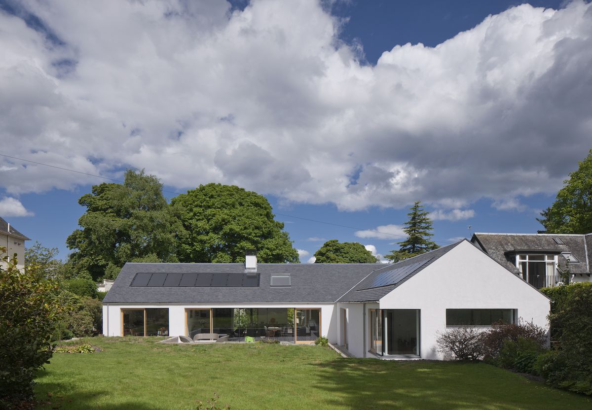 bungalow extension with solar panels and white render