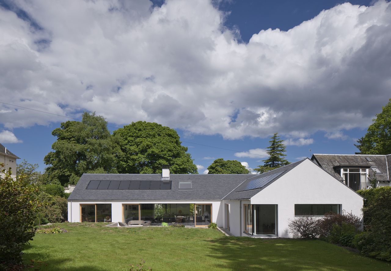 bungalow extension with solar panels and white render