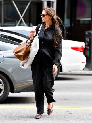 Katie Holmes wearing a sheer black shirt, black trousers, and burgundy ballet flats in New York City August 2024