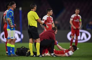 Aaron Ramsey of Arsenal recieves treatment for an injury during the UEFA Europa League Quarter Final Second Leg match between S.S.C. Napoli and Arsenal at Stadio San Paolo on April 18, 2019 in Naples, Italy.