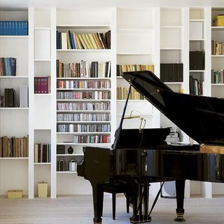 piano section with bespoke shelving and books with black piano