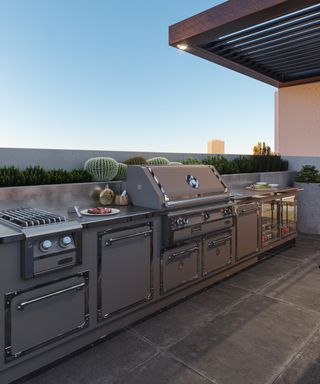A stainless steel outdoor kitchen in a setting with cacti