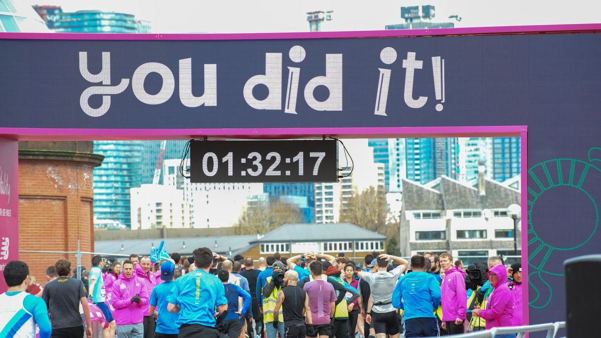 Runners are seen crossing the finishing line during The Vitality Big Half 2019