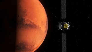 in the mid-right of the image, two three-paneled solar arrays span the image height, meeting in the center at a cubic-like spacecraft with two circular attachments. In the background on the right, starry space. On the left, the half-shadowed rusted-red planet Mars.