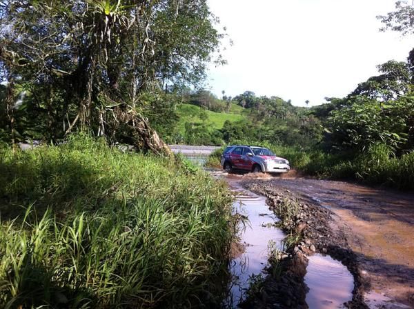 One of the official race vehicles crosses a ford.