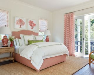 bedroom with white walls, balcony glass doors, light green and red furnishings with plush bedding