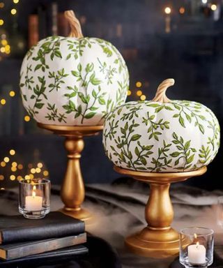 white painted pumpkins with floral and leaf stencil designs