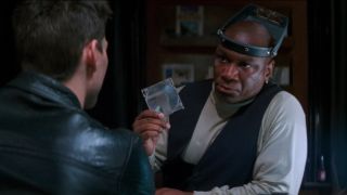 Ving Rhames holds the NOC List disc in front of Tom Cruise in Mission: Impossible.