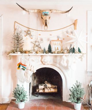 White fireplace with central bison head, hanging stars, festive gold accents and decor