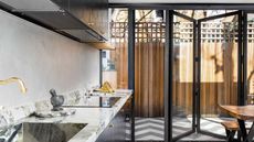 black bifold doors with level threshold and black and white zigzag flooring