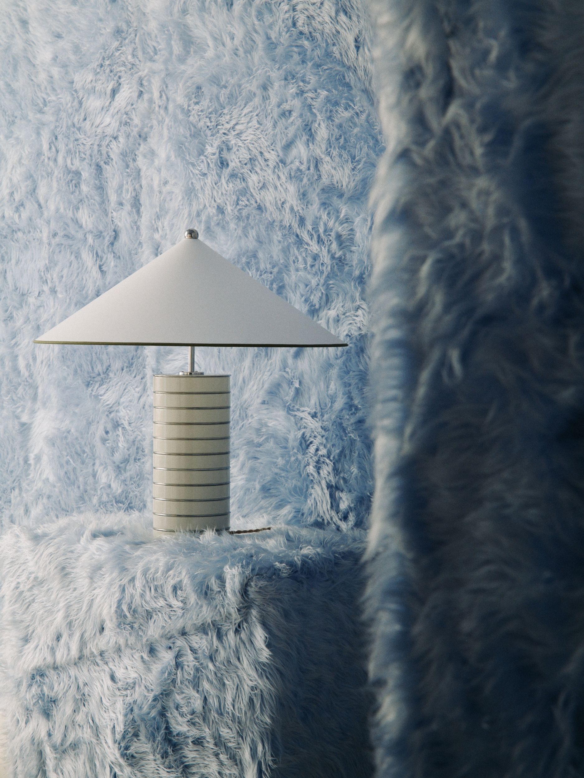 a furry blue wall with a lamp in front