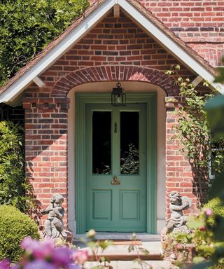 An example of how to decorate a front porch showing a green front door with a pitched roof porch