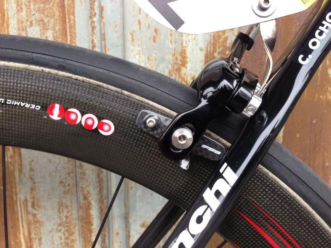 They might not save much weight but carbon brake shoes look the part, perhaps the mechanic could straighten this one before the stage starts