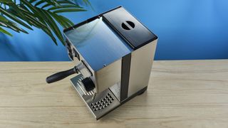 Rancilio Silvia in Stainless steel on a wooden worktop with a blue wall in the background.