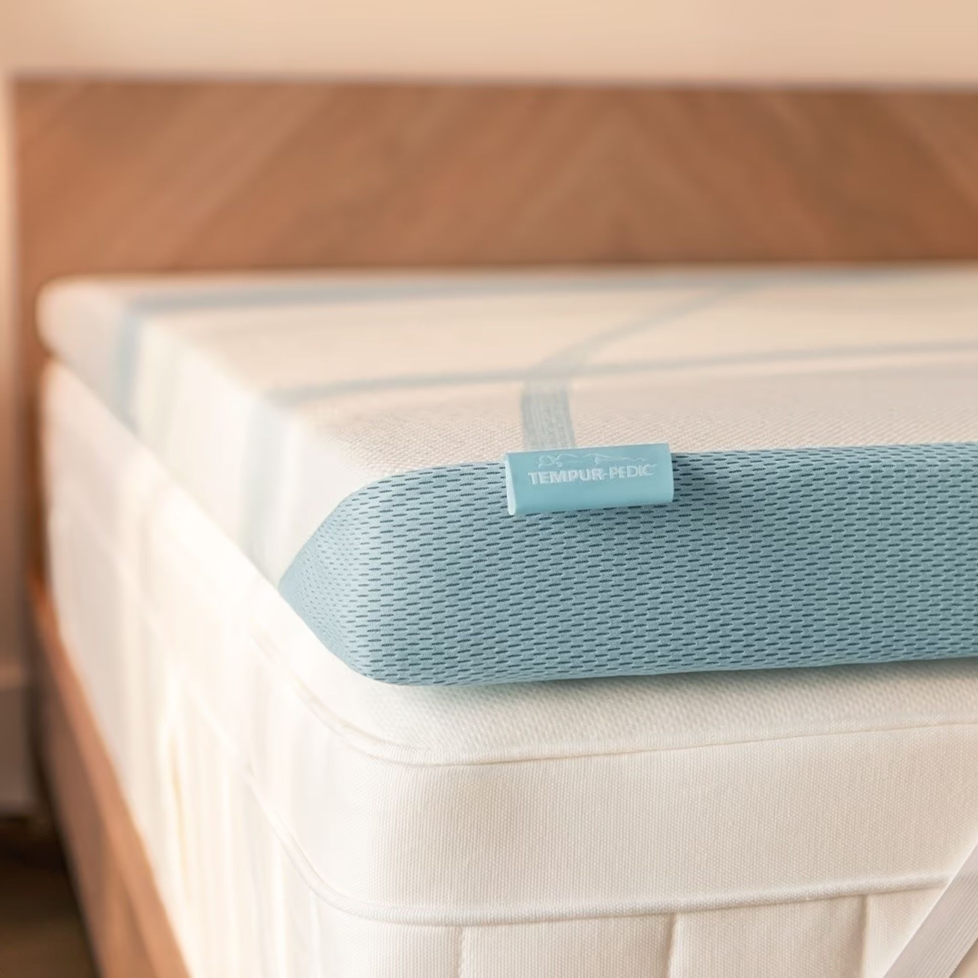 Tempur-Pedic Adapt Topper on a white mattress and wooden bedframe