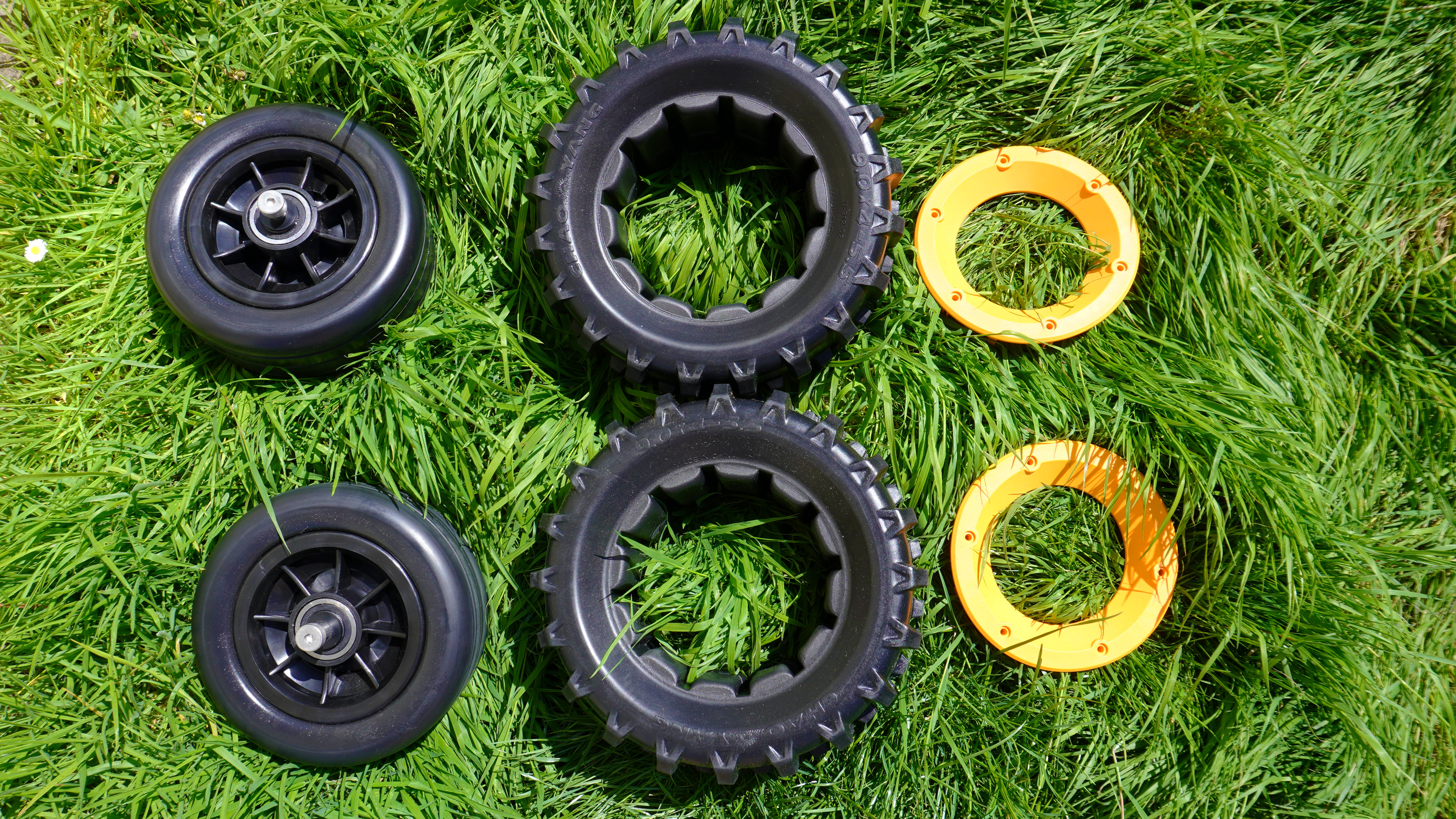 Wheels of the Mowrator S1 2WD lawnmower photographed on green grass.