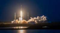 a black-and-white spacex falcon 9 rocket launches into a darkening evening sky.