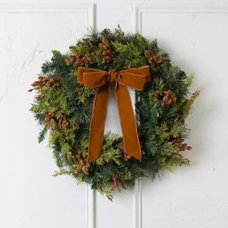 An ivy Christmas wreath with a large velvet bow
