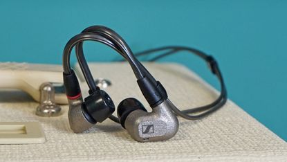 Sennheiser IE 600 on top of white-colored amp