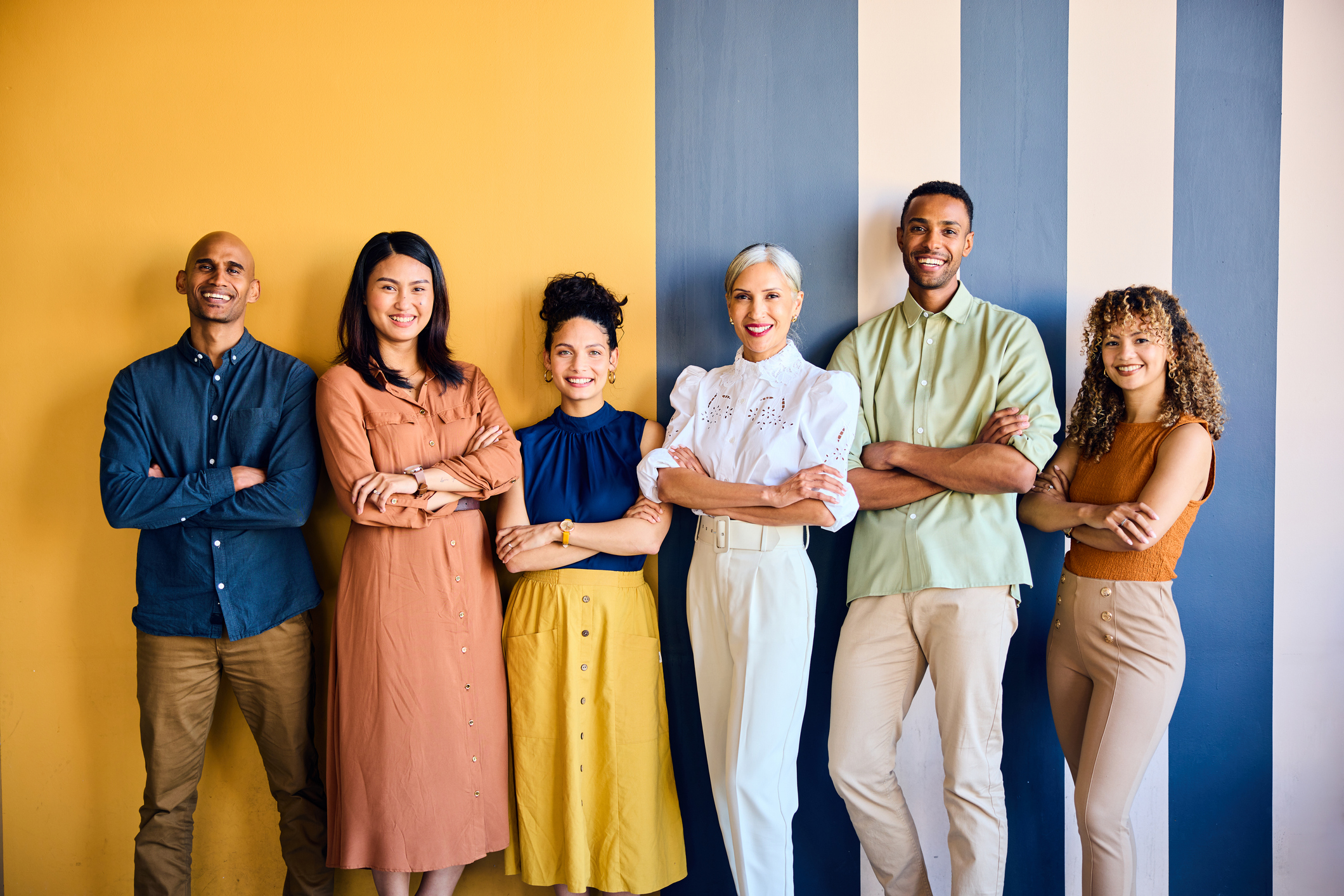 Cheerful multiracial business colleagues with arms crossed.