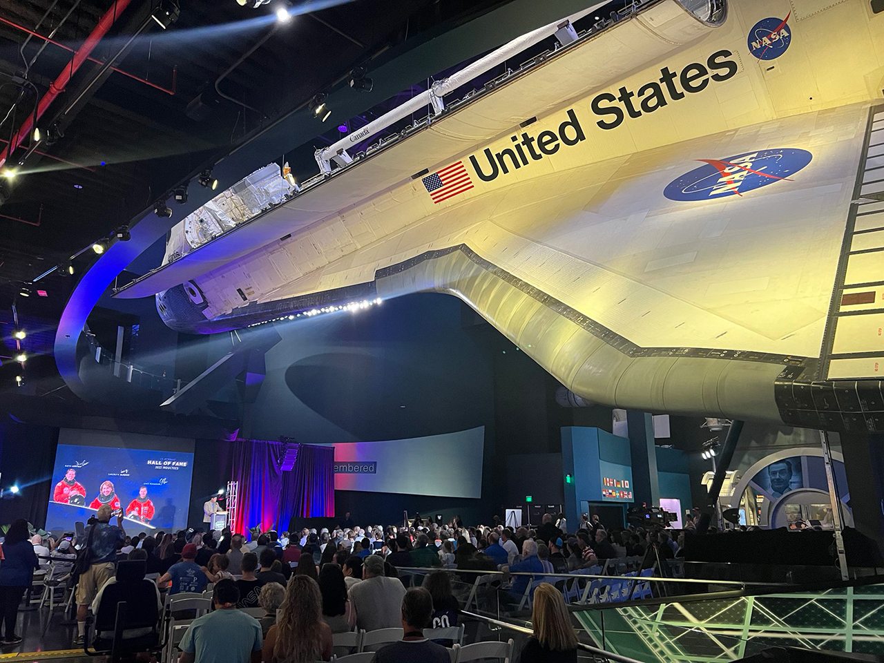 The 2022 U.S. Astronaut Hall of Fame induction ceremony was held under the display of the space shuttle Atlantis, a spacecraft on which all three inductees flew, at the Kennedy Space Center Visitor Complex in Florida.