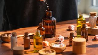 Woman pouring essential oils into brown glass