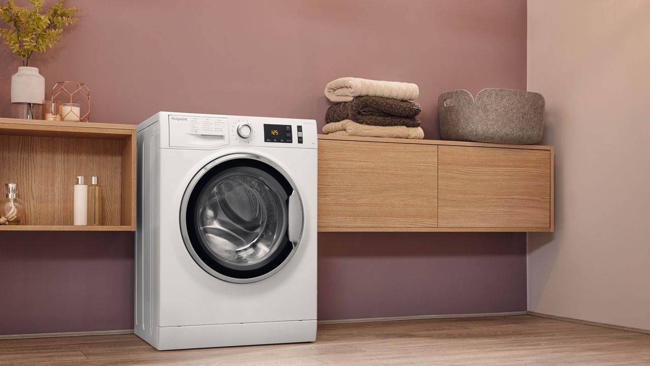 utility room with blush pink scheme and wooden sideboards and washing machine by AO