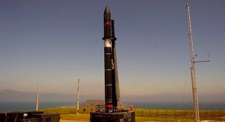 A Rocket Lab Electron booster stands ready to launch the company's Love At First Insight mission from a pad on the Mahia Peninsula in New Zealand. Liftoff is set for 5:25 p.m. NZT on Nov. 11 (11:25 p.m. EST Nov. 10).