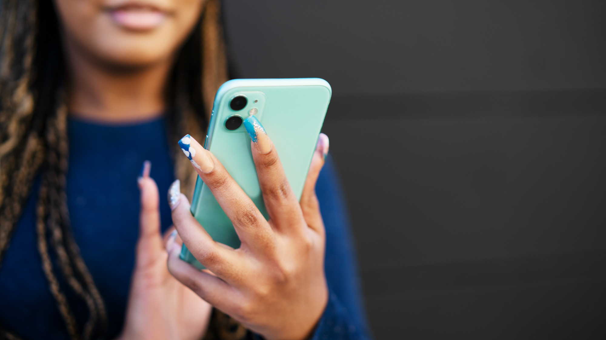 An image of a person holding an iPhone with both hands.